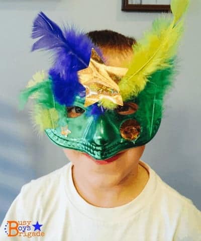 young boy wearing mask with feathers