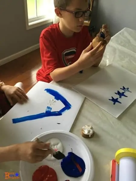 Painting with star potato stamps is a fun and easy to make patriotic crafts with kids.