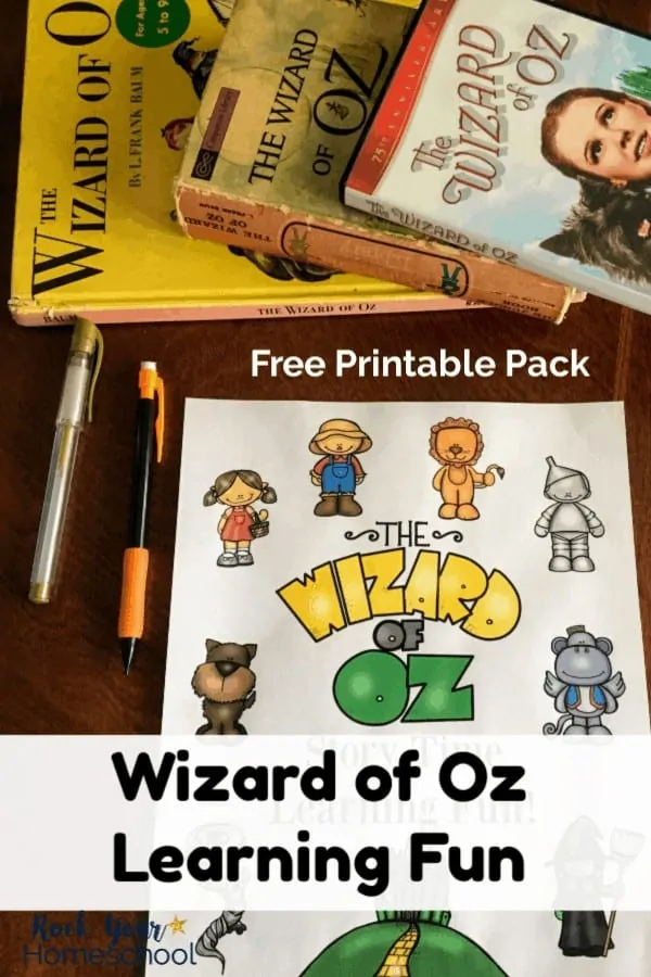 Free printable Wizard of Oz Learning Fun pack on dark wood desk with gold pen & orange mechanical pencil and Wizard of Oz books & DVD case