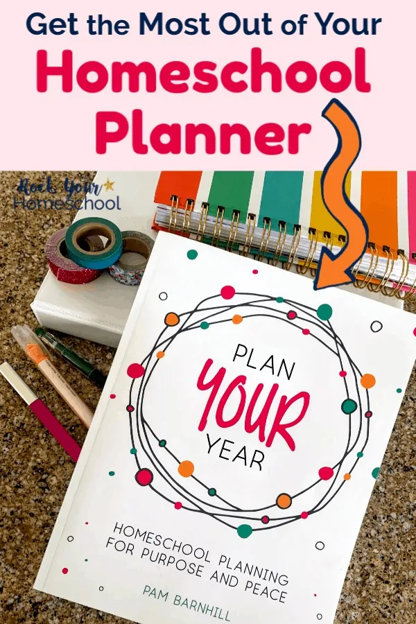 Plan Your Year book with white 3-ring binder, Living Well Planner striped, washi tapes, and pens on granite surface