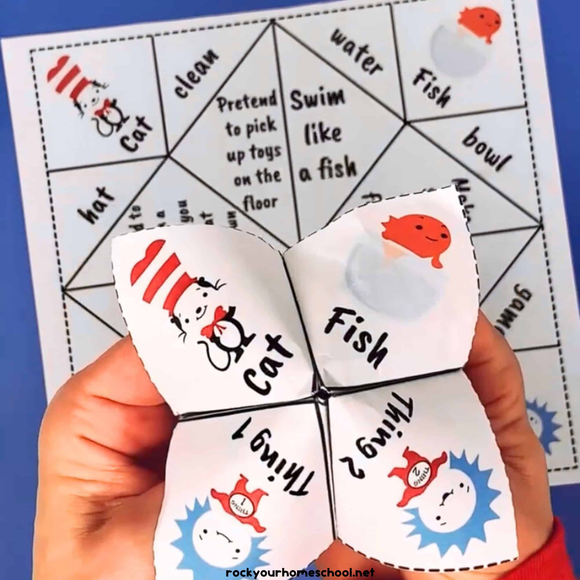 Boy holding Dr. Seuss-inspired cootie catcher with example of page in background.