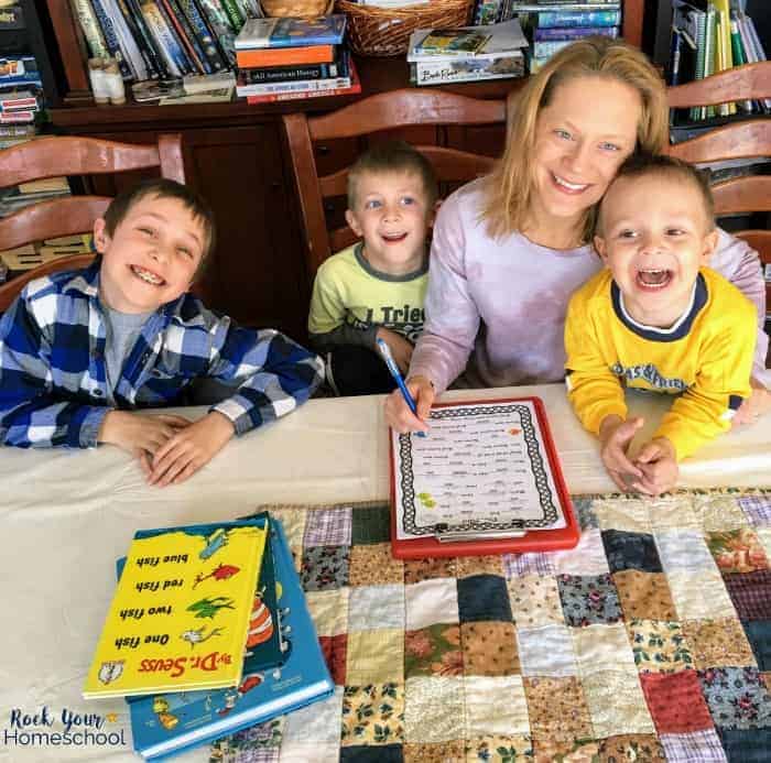 Smiling mom and her three sons with free printable Dr. Seuss Mad Libs and Dr. Seuss books.