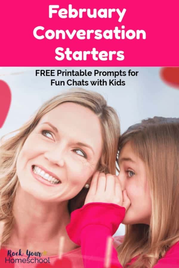 Daughter with bright pink shirt whispering into smiling mom's ear with red paper hearts hanging from wooden clothes pins in background