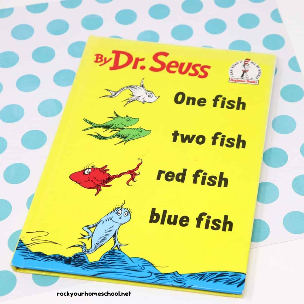 One fish two fish red fish blue fish book by Dr. Seuss book on light blue polka dot paper.