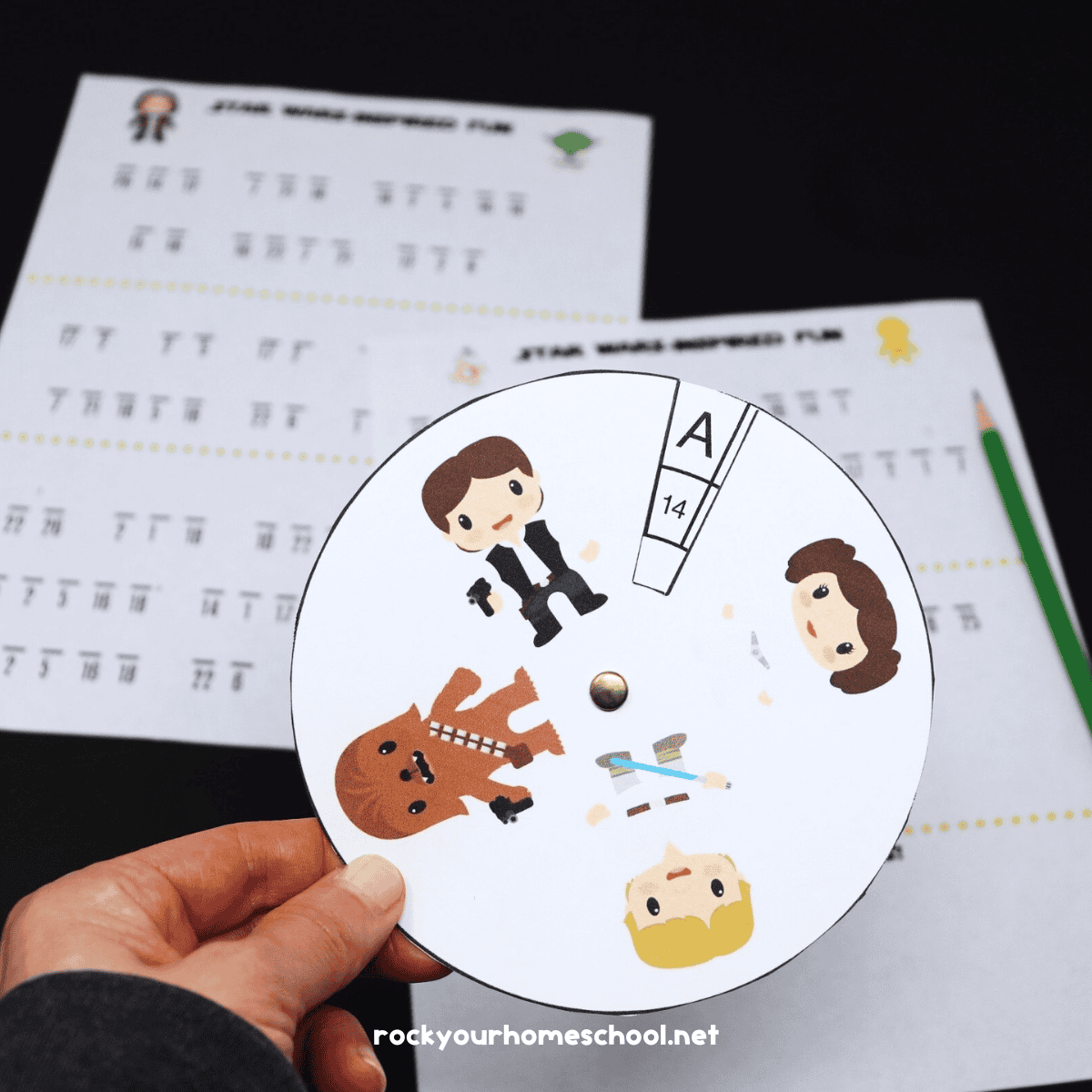 Woman holding example of free printable Star Wars decoder wheel with decoding activities in background.