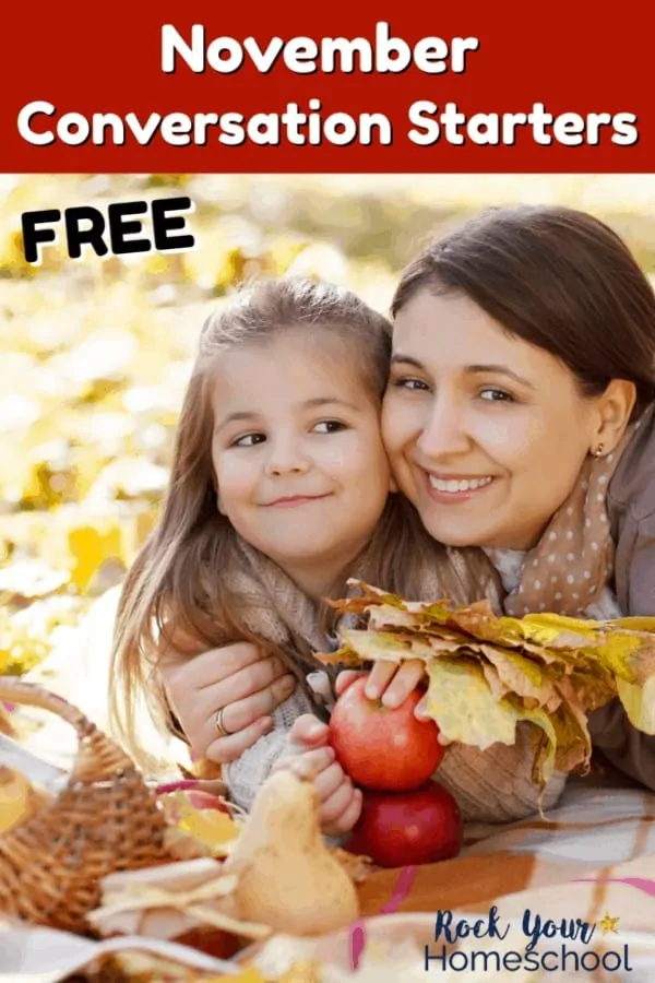 Mother & daughter holding leaves & apples as they smile while having November fun chats