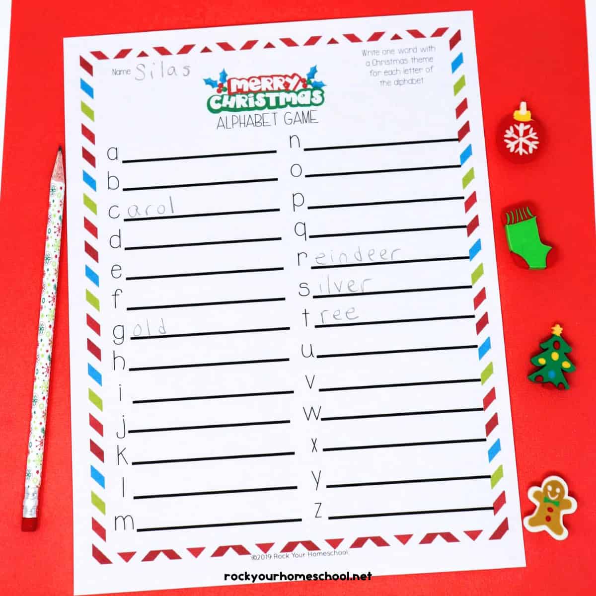 Christmas Alphabet Game printable page with Christmas pencil & mini-erasers on red background.