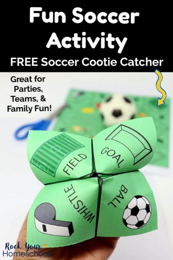 Woman\'s hand holding a soccer cootie catcher featuring a field, goal, whistle, and ball with blue scissors, soccer cootie catcher printable page, &amp; small toy soccer ball in background