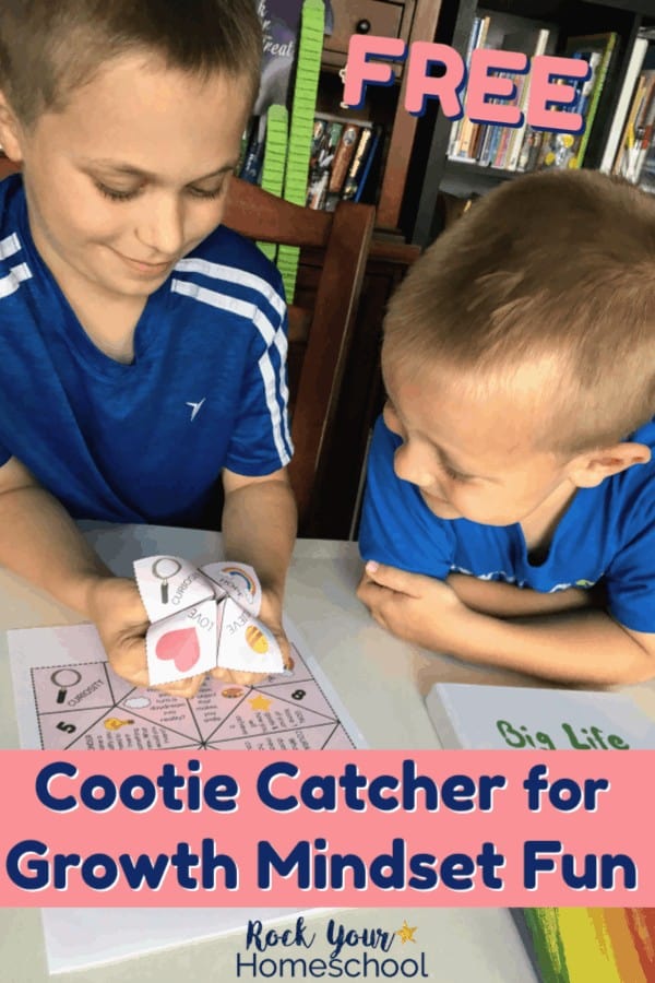 Two boys smiling as they use a growth mindset cootie catcher to learn & practice growth mindset skills