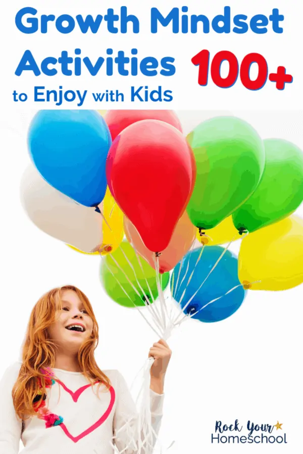 Smiling red-haired girl with heart on shirt holding rainbow of balloons
