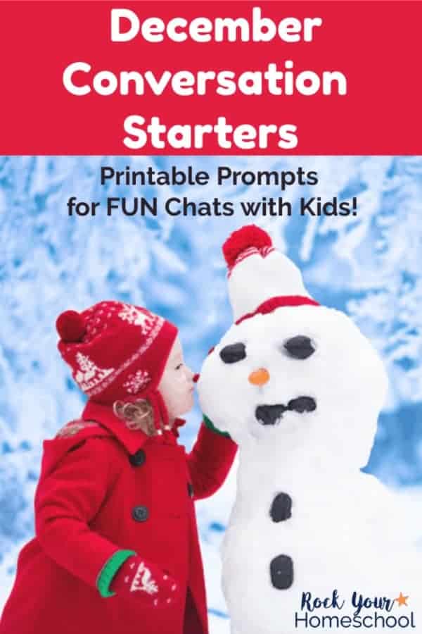 Little girl in red coat & hat whispering to snowman with snowy trees & snow in background