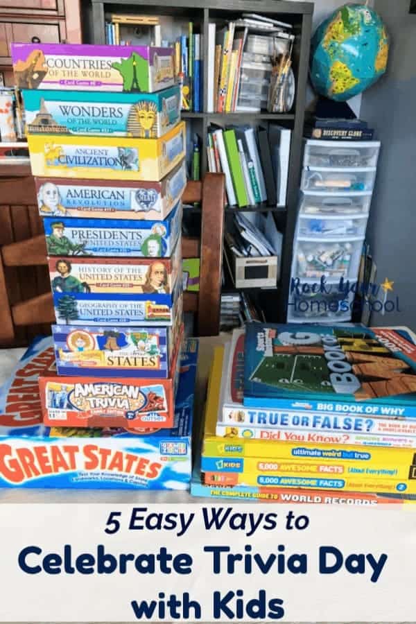 Stacks of trivia games & books on table with homeschool supplies in background