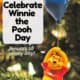 Winnie the Pooh hanging from blue balloon ornament with Christmas tree in background for a wonderful way to celebrate Winnie the Pooh Day