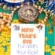 New Year's Eve display with pocket watch with Roman numerals, navy and gold tinsel, string of gold beads, and yellow stars on green background with cover of New Year's Eve Fun with Your Kids activity pack