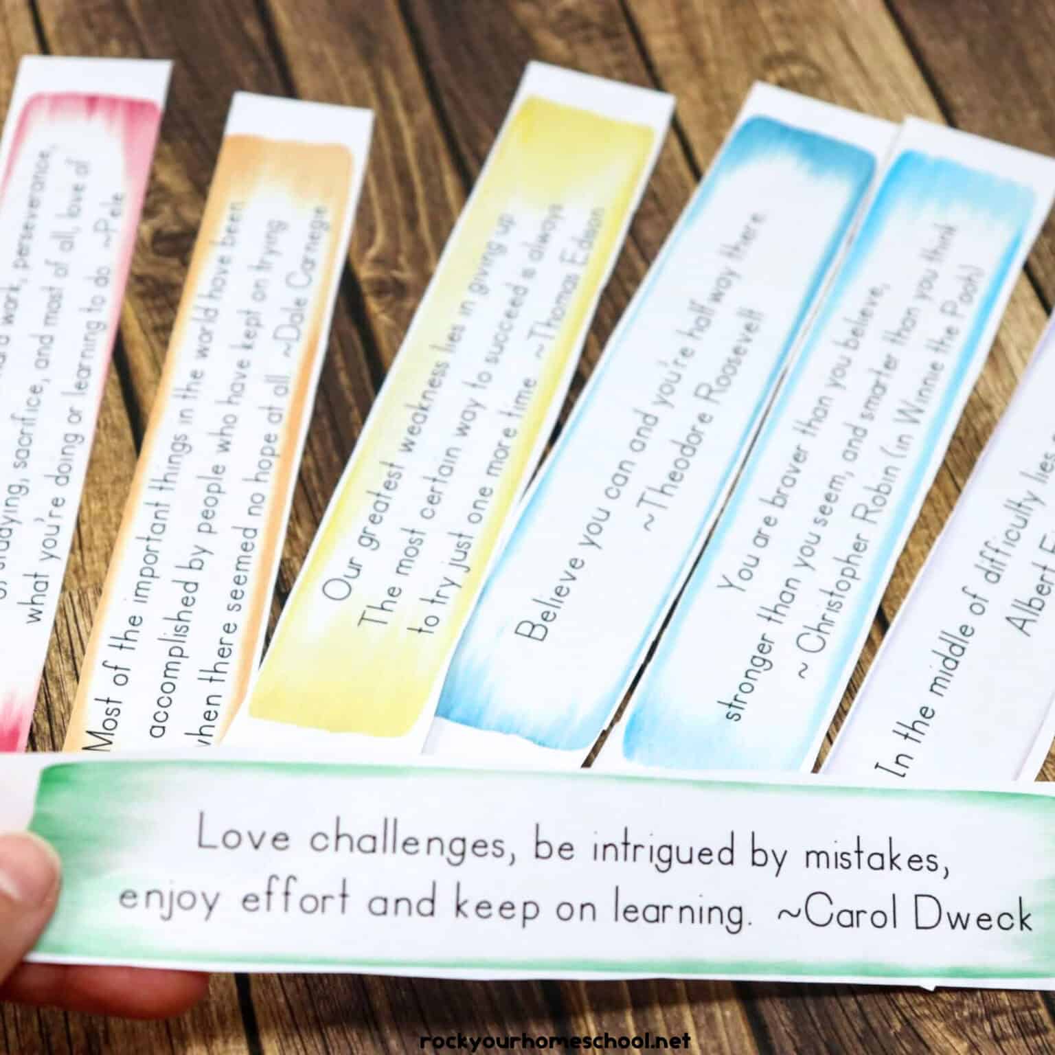 Woman holding printable growth mindset quote by Carol Dweck with examples in background.