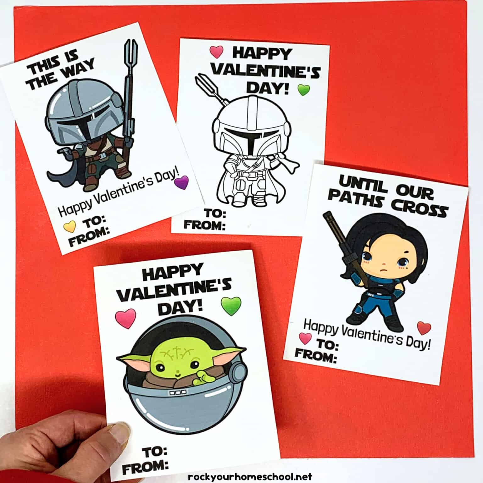 Woman holding free printable Mandalorian Valentine's Day card with other examples in background.