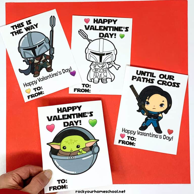 Woman holding free printable Mandalorian Valentine's Day card with other examples in background.