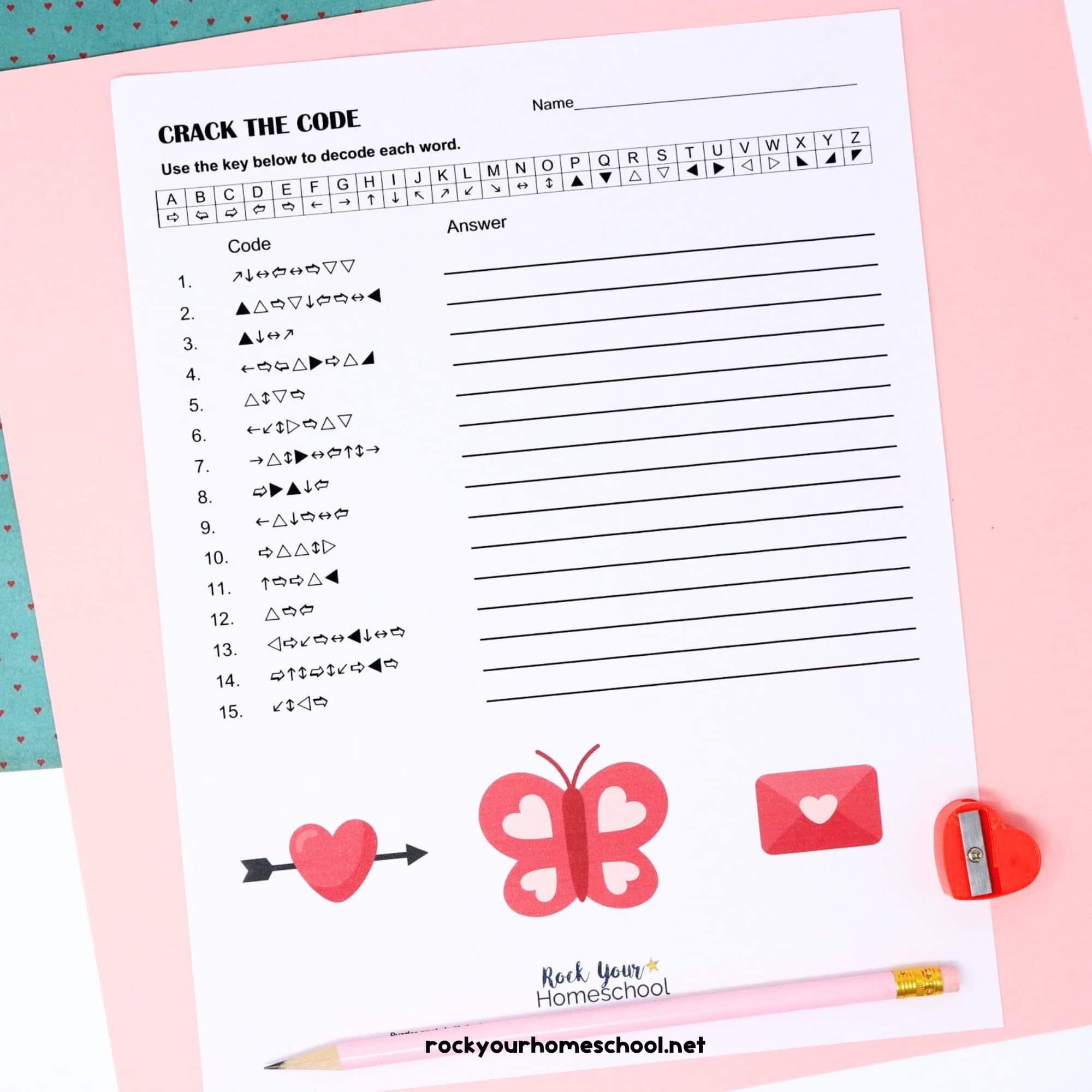 Free Valentine's Day Crack the Code Activity with pink pencil and red heart-shaped pencil sharpener on pink paper & blue paper with tiny red hearts.