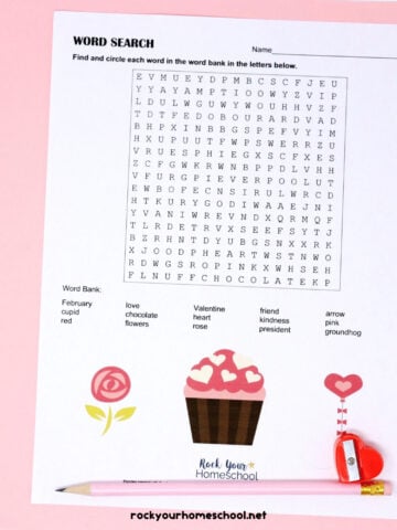 Free Valentine's Day Word Search with pink pencil and red heart-shaped pencil sharpener on pink paper.