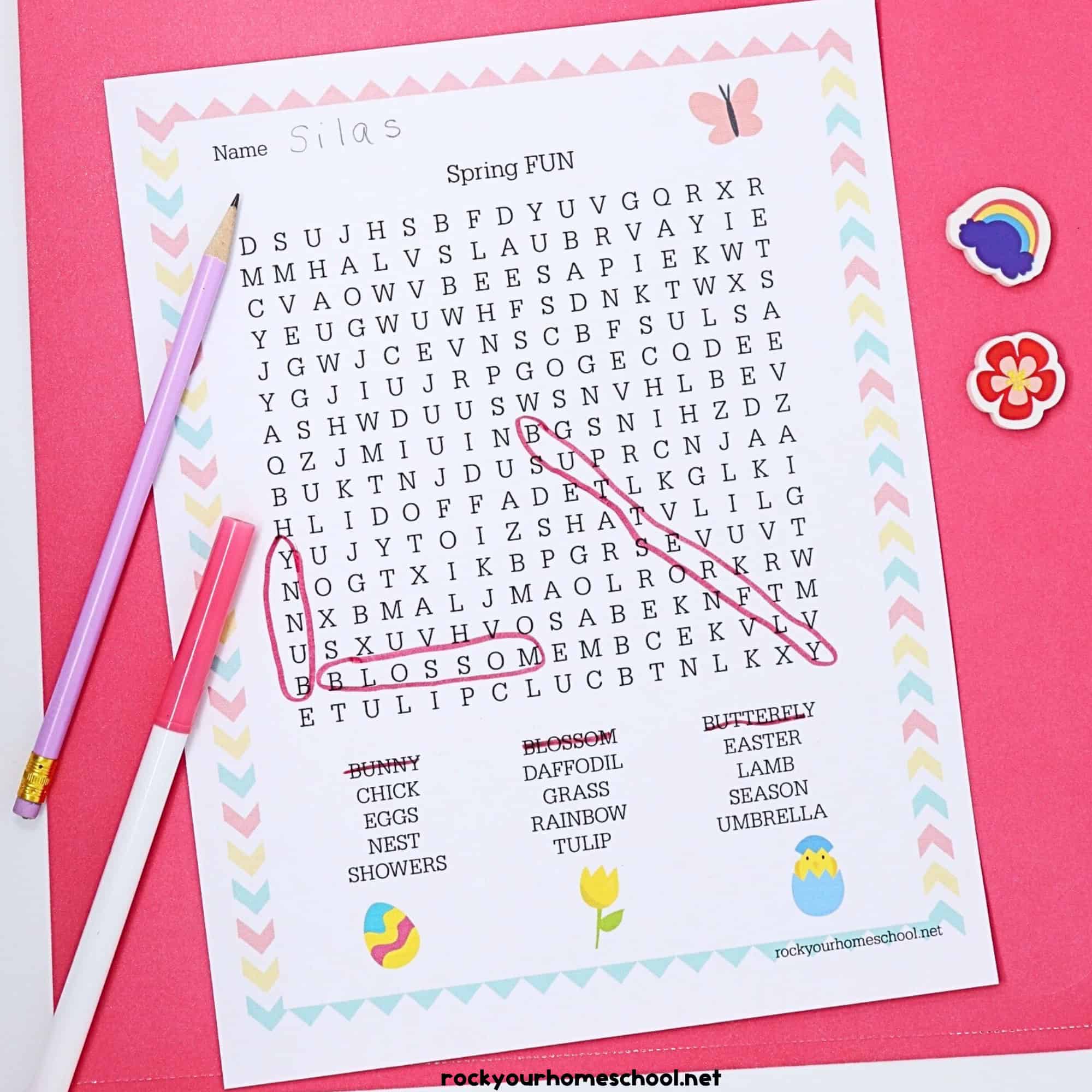 Free Spring Fun Word Search and pink marker & light purple pencil & mini-erasers on pink paper.