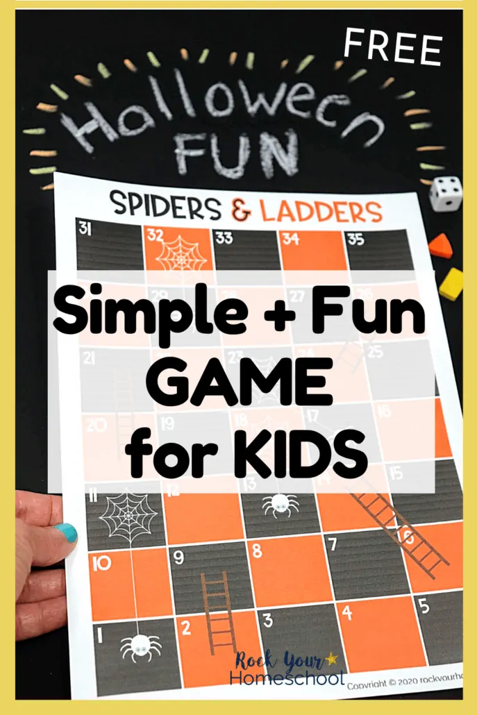 Woman holding Spiders and Ladders game board with Halloween Fun written on black chalkboard to feature the amazing fun you\'ll have with this free Halloween game for kids
