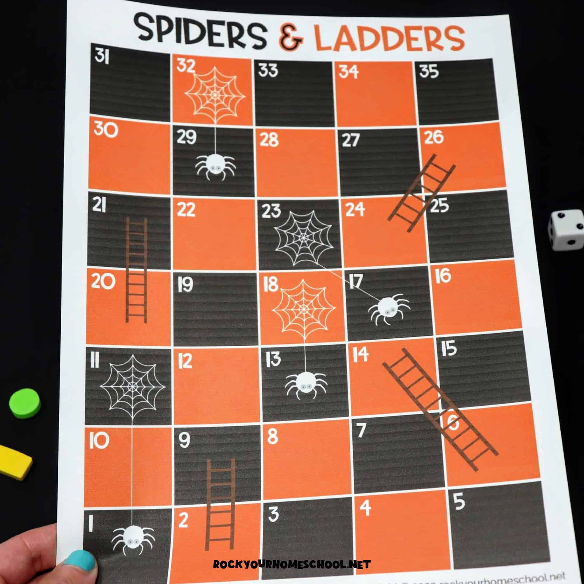 Woman holding example of free printable Halloween game of Spiders and Ladders.