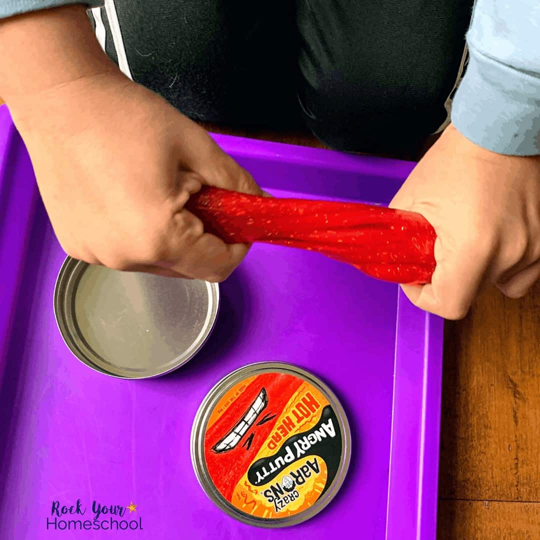 Boy using Crazy Aaron's Thinking Putty (Angry Putty version) as a creative and fun homeschool tool