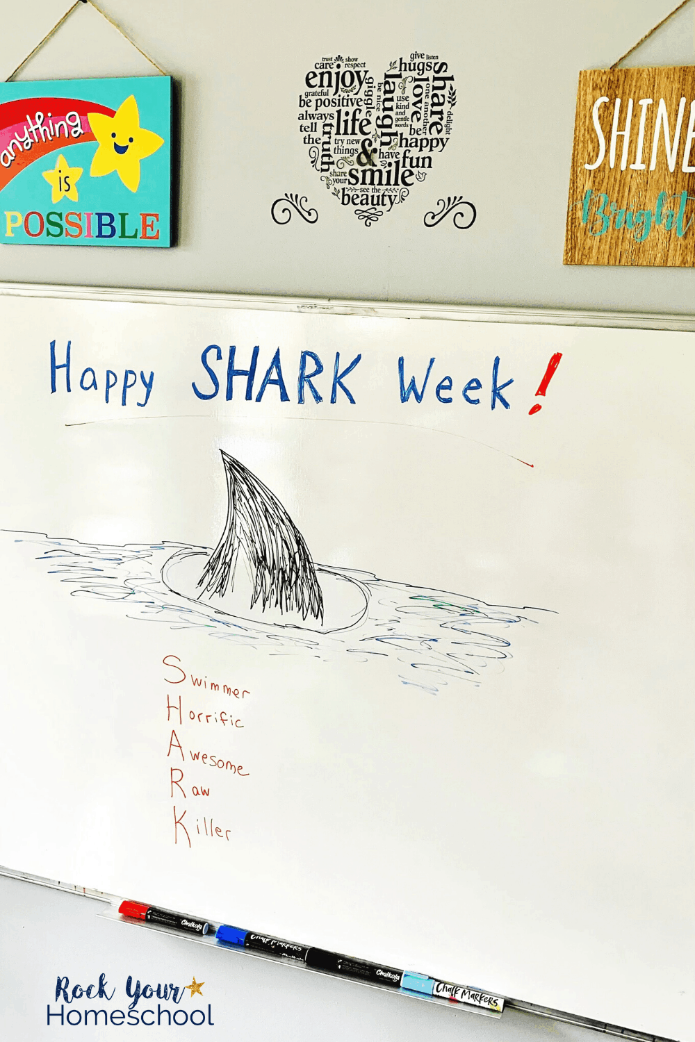 Whiteboard with Happy Shark Week & shark fin drawn with chalk markers to feature these cool school art supplies