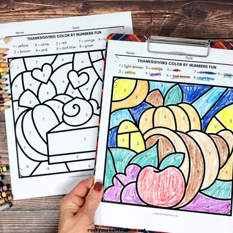 Woman holding example of Thanksgiving color by number page on clipboard.