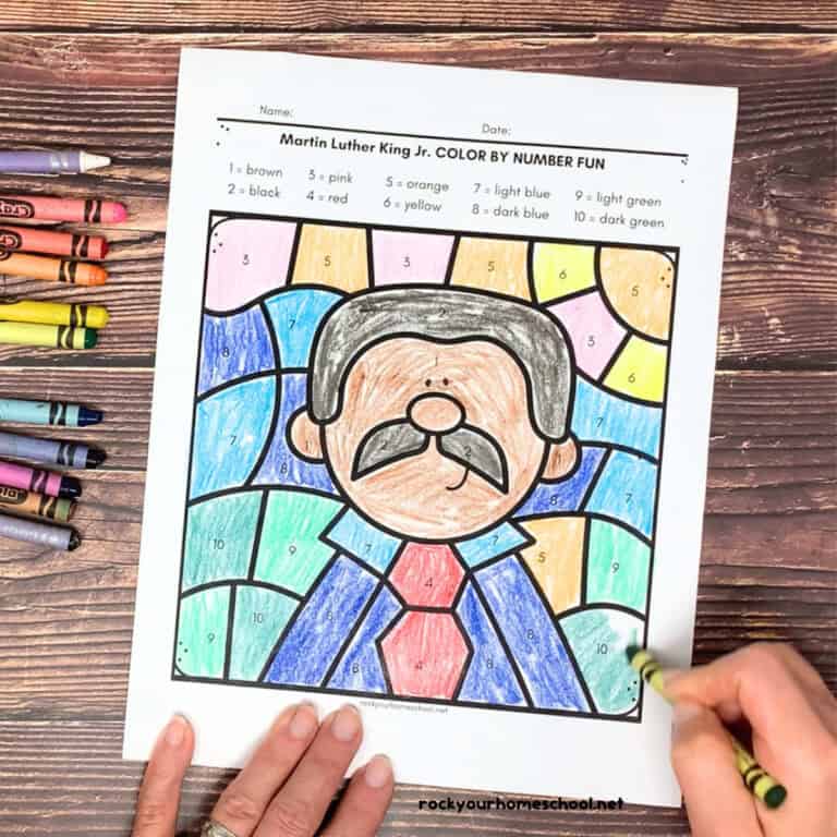 Woman carrying Martin Luther King Jr. color by number page with crayons.