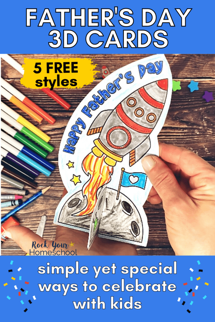 Woman holding 3D card that says HAPPY FATHER'S DAY with rocket and rainbow of color markers, pencil, crayons, star erasers, and glue stick on wood background to feature this free printable set of Father's Day cards for kids