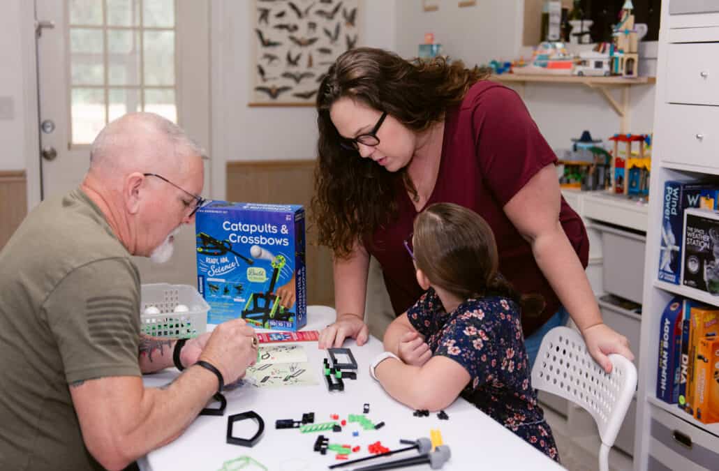 Jessica of The Waldock Way with her husband and daughter working on a science project to feature how to make homeschooling an only child fun
