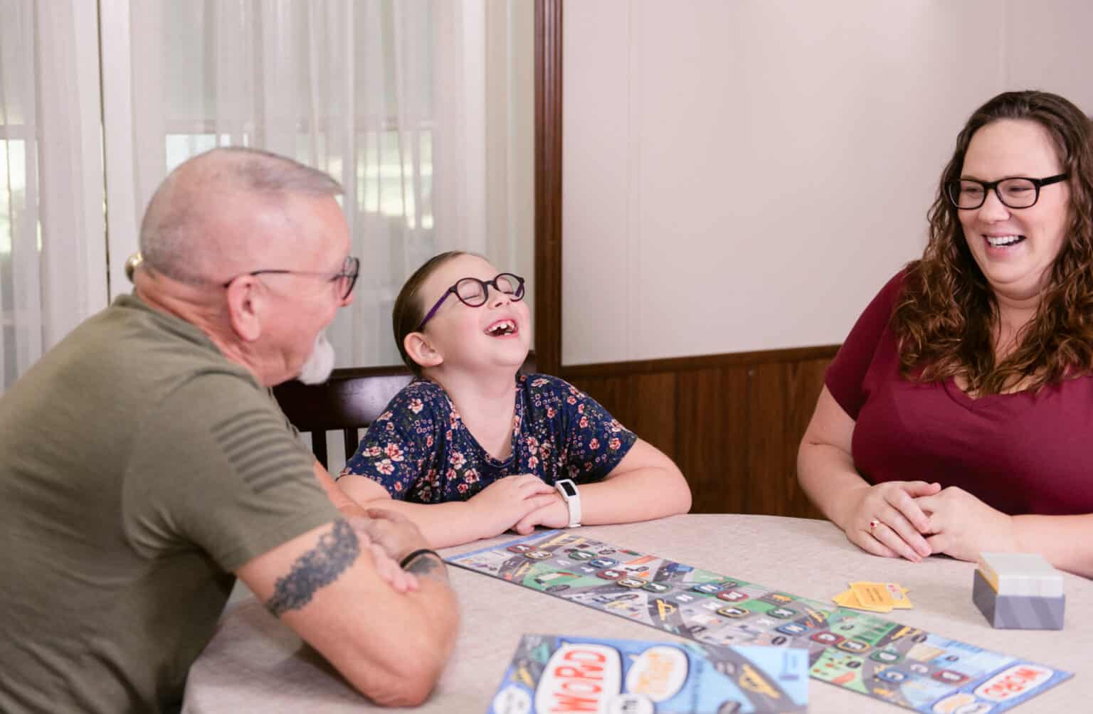 Jessica of The Waldock Way with her husband and daughter laughing as they play a game to feature how to make homeschooling an only child fun