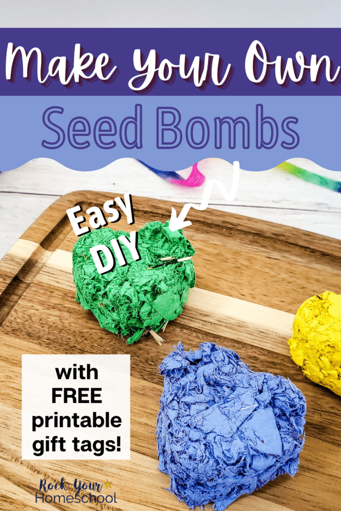 3 heart-shaped seed bombs for kids in green, blue, and yellow on wood cutting board to feature this simple project that include free printable gift tags