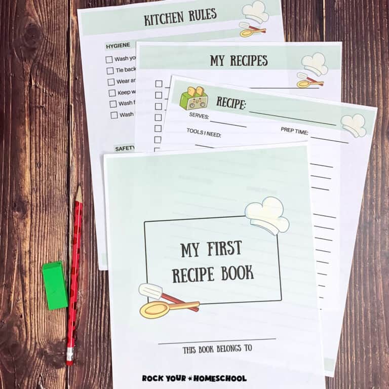 Woman holding cover page of My First Recipe Book with red pencil and green eraser on wood background with other free printable recipe book for kids pages.