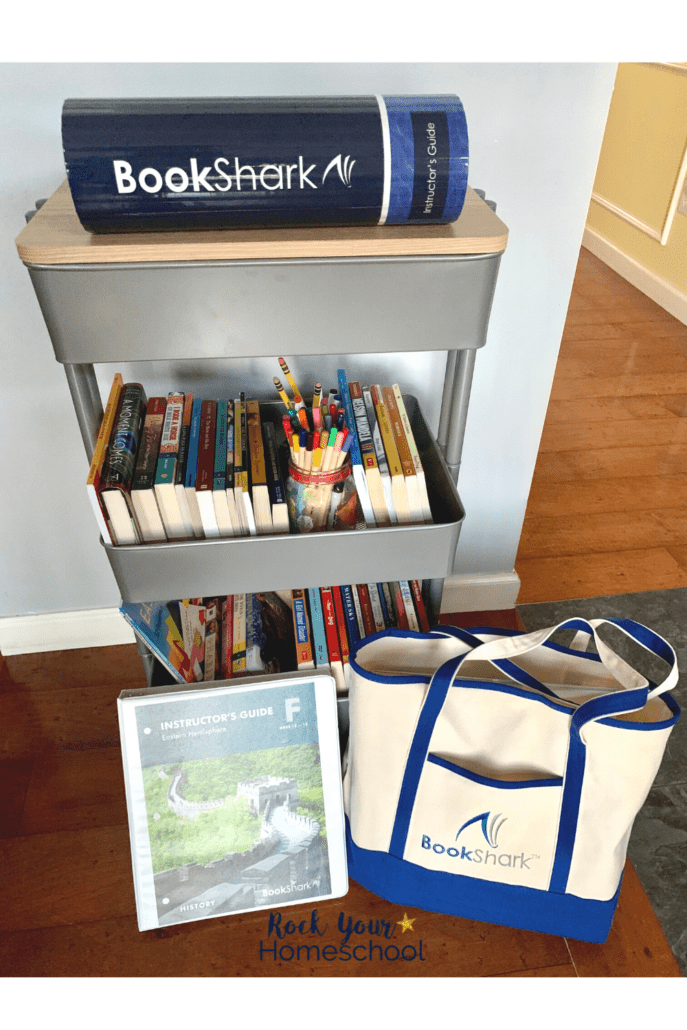 rolling cart with BookShark Reading with History F materials, instructor's guide, and BookShark tote bag