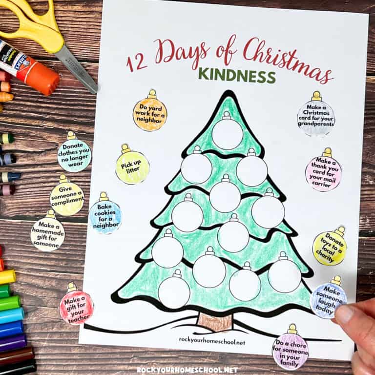 Woman holding example of free printable Christmas random acts of kindness activity with tree and ornaments.