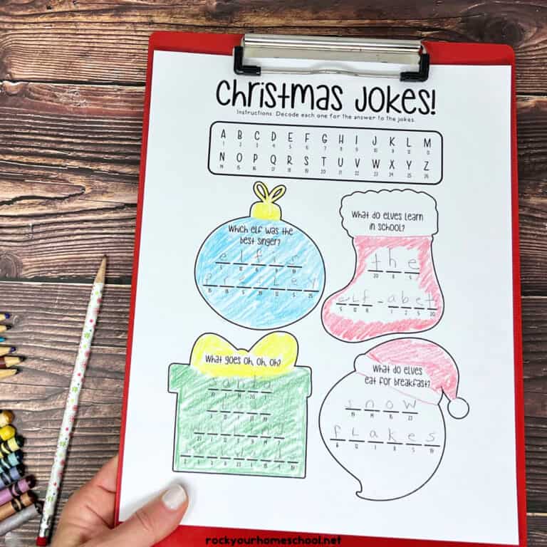 Woman holding red clipboard with example of free printable crack the code Christmas jokes for kids.