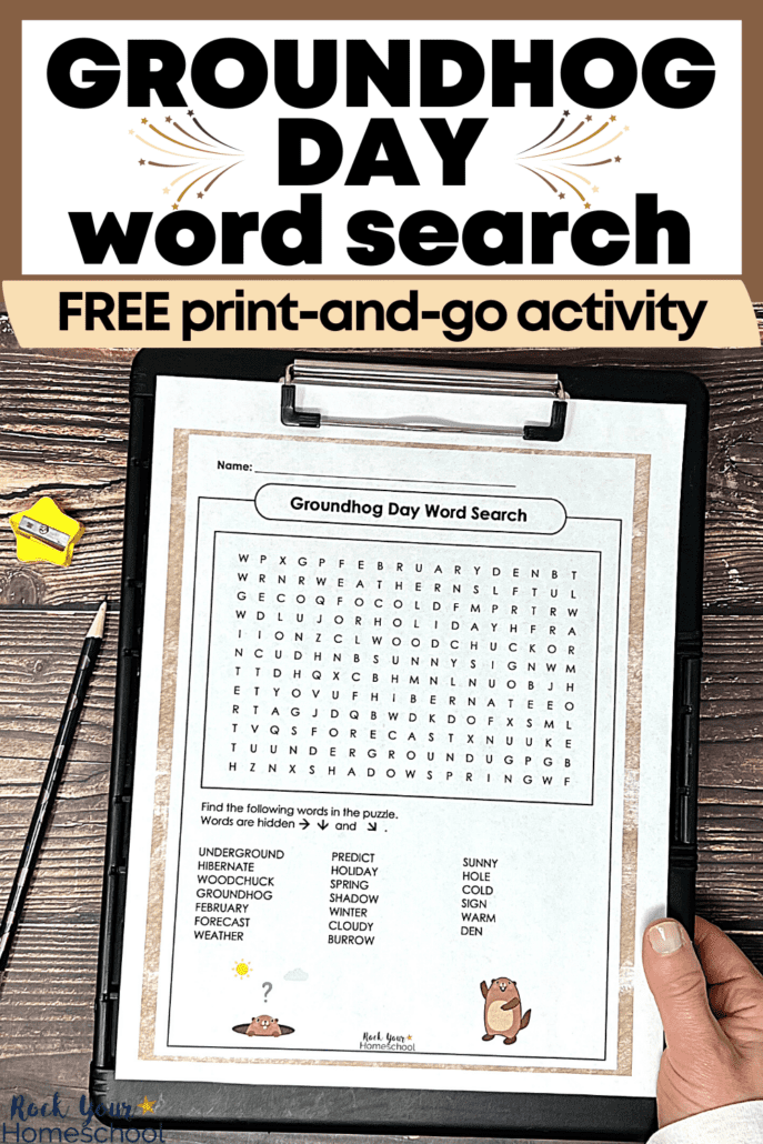 woman holding free printable Groundhog Day word search on black clipboard with purple pencil and yellow star pencil sharpener on wood background