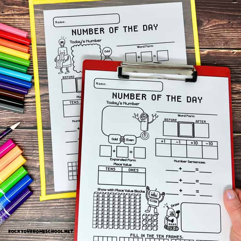 Woman holding clipboard with number of the day worksheets.