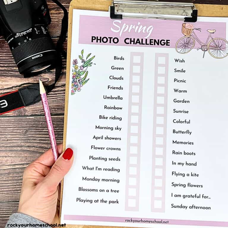 Woman holding clipboard with spring photo challenge and camera.