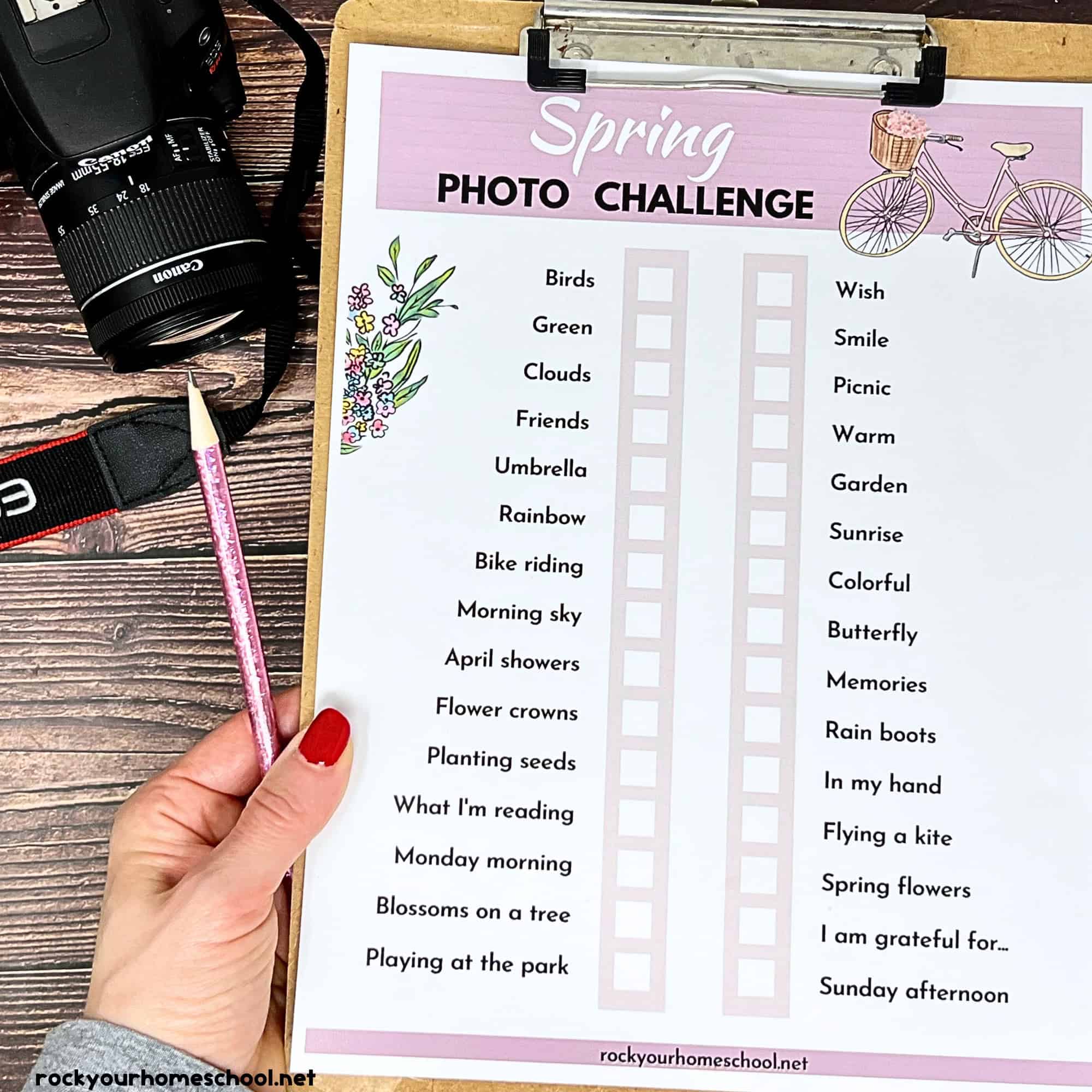 Woman holding clipboard with spring photo challenge and camera.