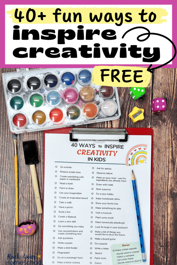 free printable list of 40+ ways to inspire creativity in kids on red clipboard with blue pencil with watercolor paints, dice, yellow star-shaped pencil sharpener, and painted rock in background.