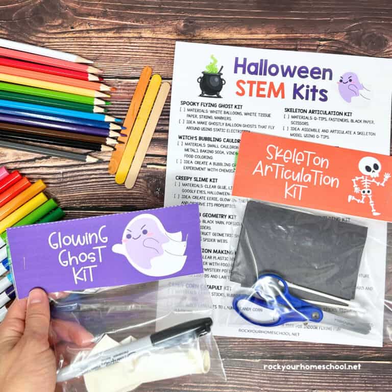 Woman holding example of Halloween STEM kit featuring Glowing Ghost with list of ideas, color pencils, markers, popsicle sticks, and more in background.