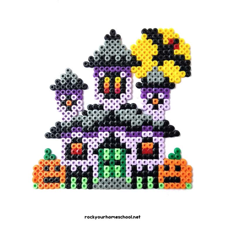 Example of haunted house perler bead craft that has jack-o'-lanterns, bat, moon, and more.