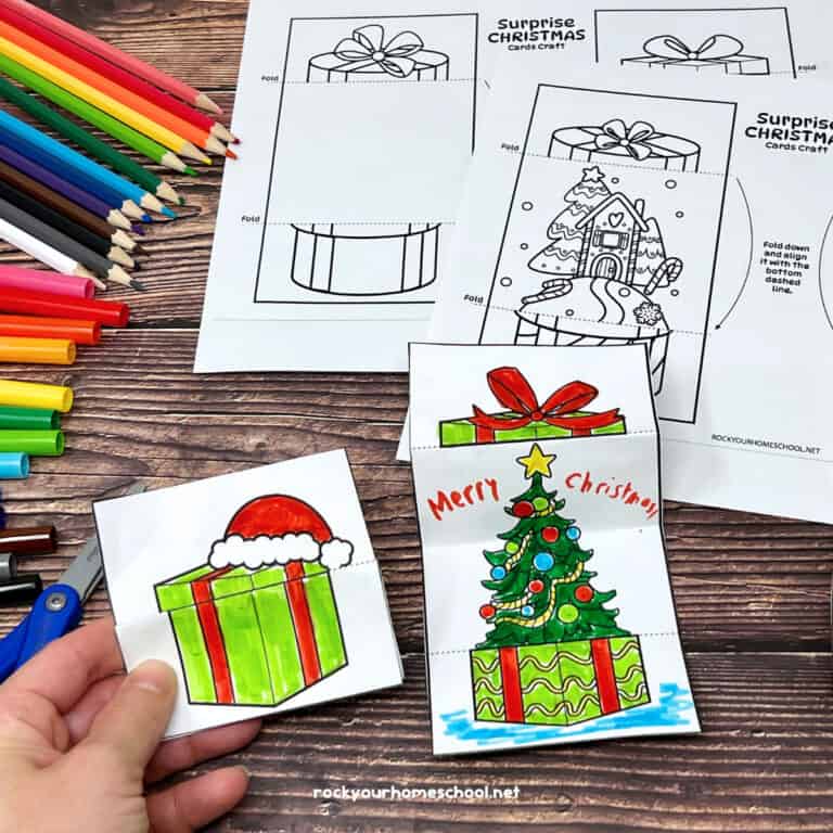 Woman holding DIY coloring card with other templates and examples of free Christmas cards for kids.