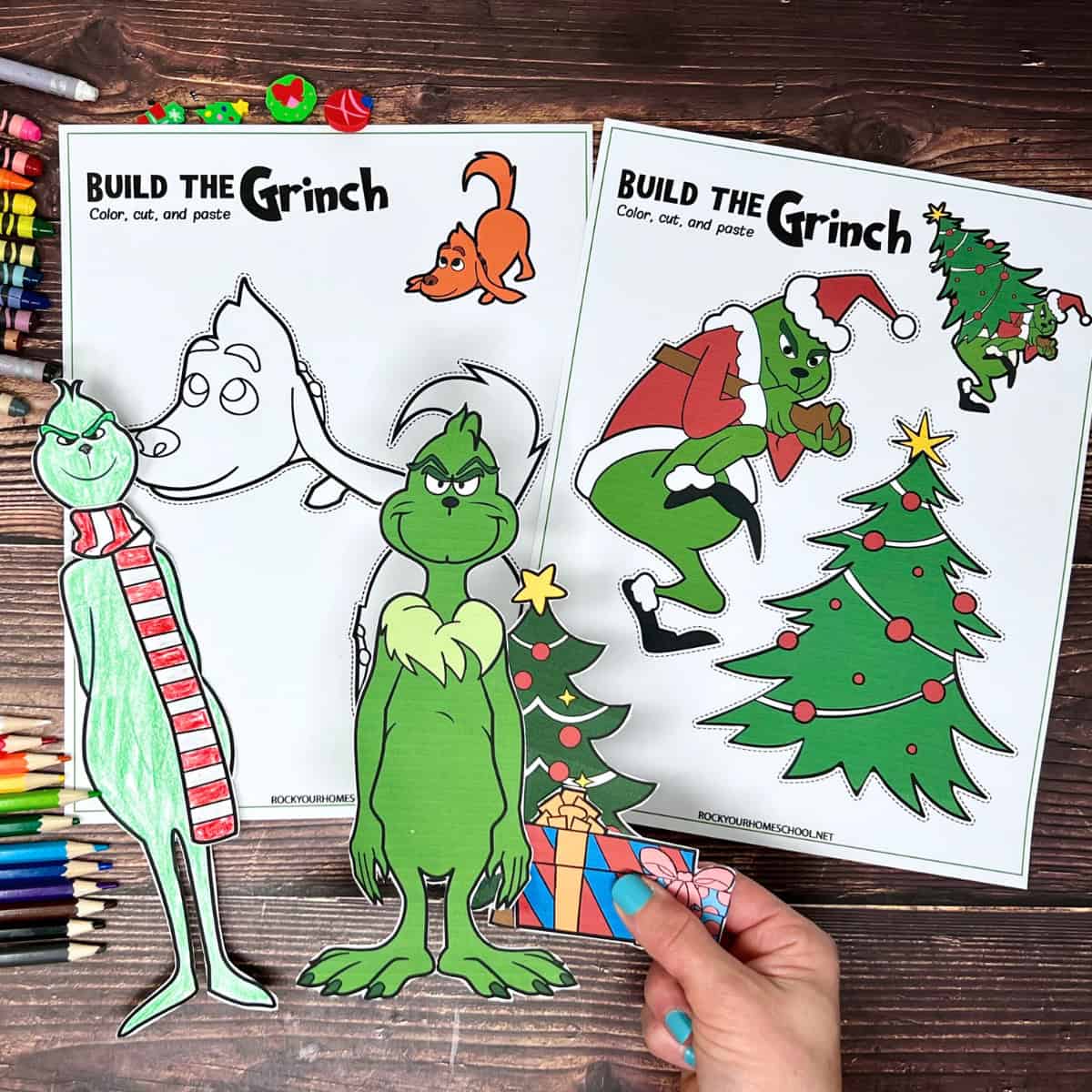 Woman holding free printable Grinch Christmas craft to with examples in background.