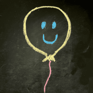 Black chalkboard with chalk balloon and smile face.