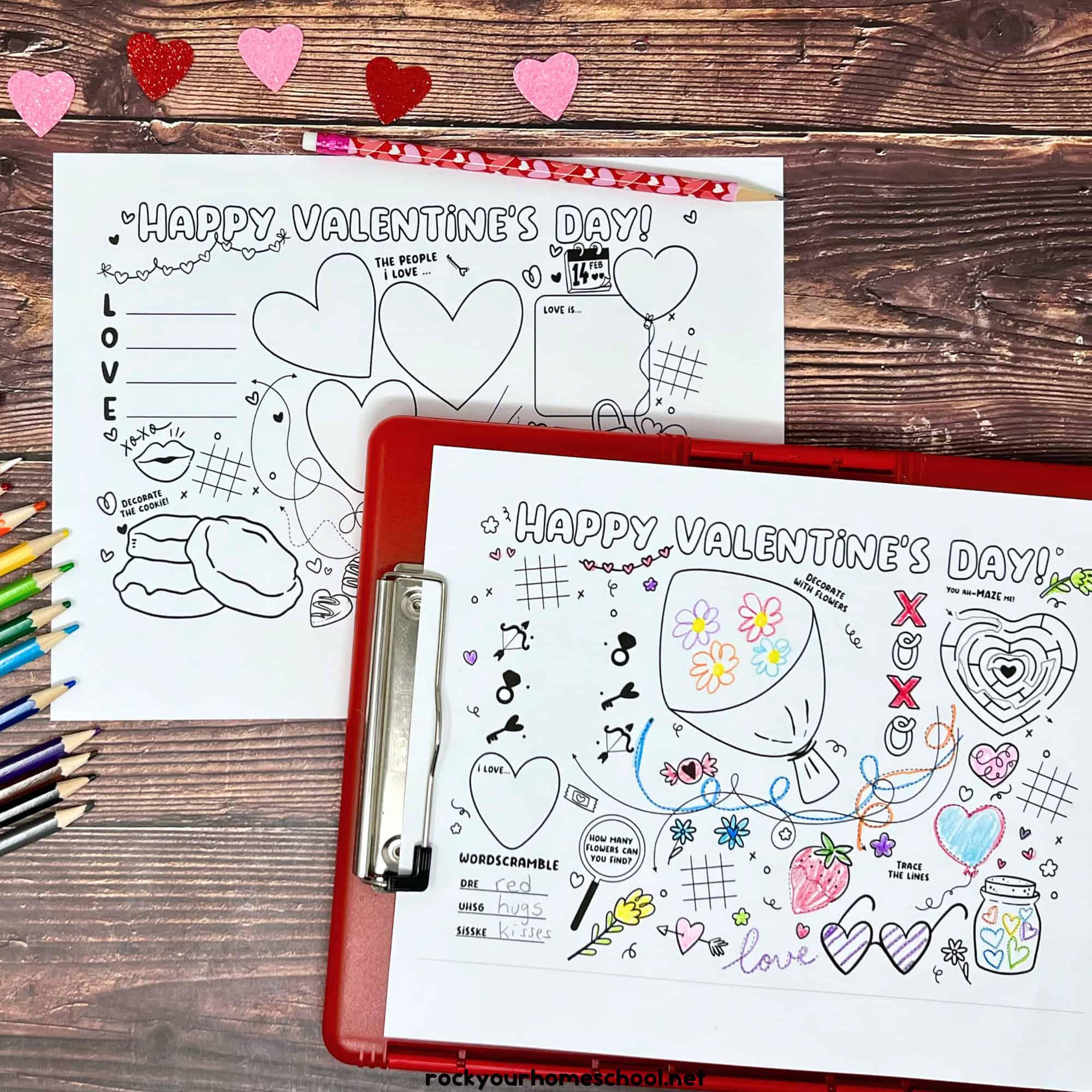 Examples of the free printable Valentine's Day activity sheets on red clipboard with crayons, color pencils, and glitter hearts.