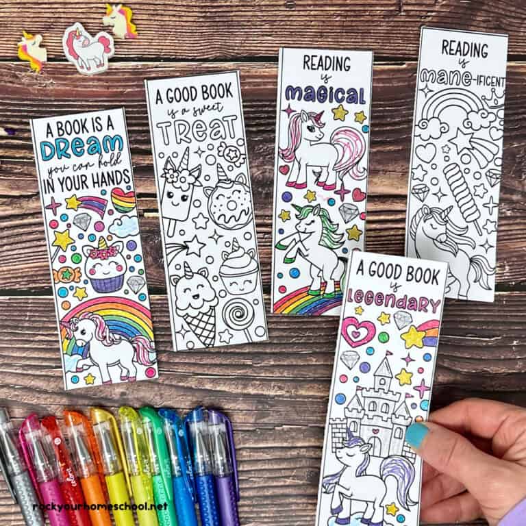 Woman with examples of free printable unicorn bookmarks to color with gel pens.